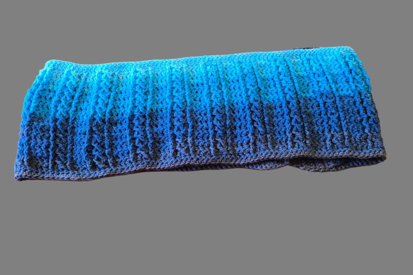 Multi-color aqua, blue, and gray knitted cowl scarf, 52 inches long and 9 inches wide.