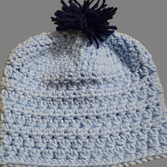 Light blue baby hat with dark blue pom pom for 6-9 months infants, part of a cozy baby cardigan and hat set