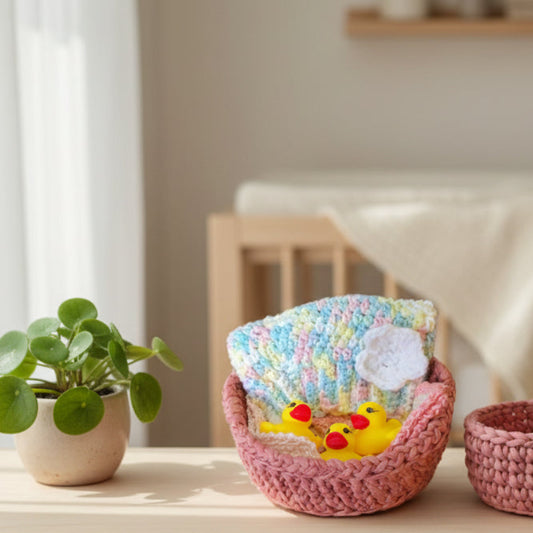 Pink gift basket for newborn baby girl with washcloths, hat, and rubber duck bath toys