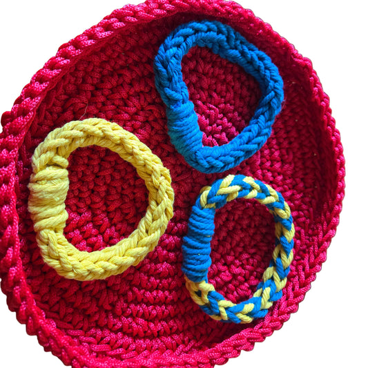 Three bangle bracelets made from macrame cord in colors yellow, blue, yellow and blue combination.