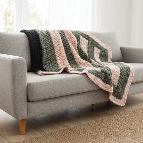 Crocheted stitch by stitch in a harmonious palette of gray and pink, this 34" x 26" throw embodies the quiet luxury of slow-made textiles. Made by Stitched Creations