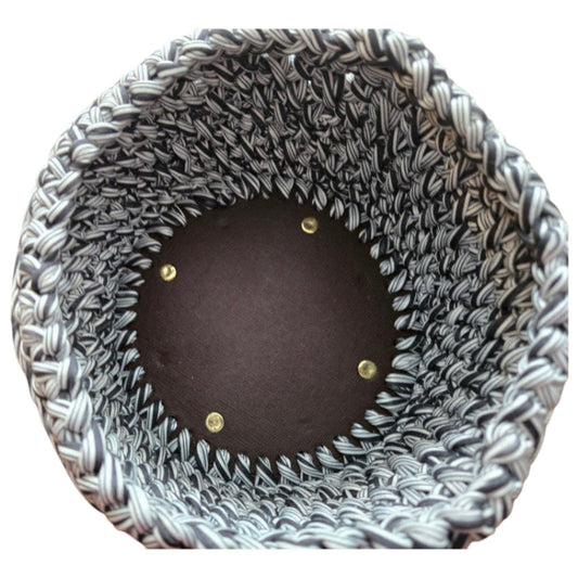 Round handmade basket in black and white, crafted from t-shirt yarn with a wood base.