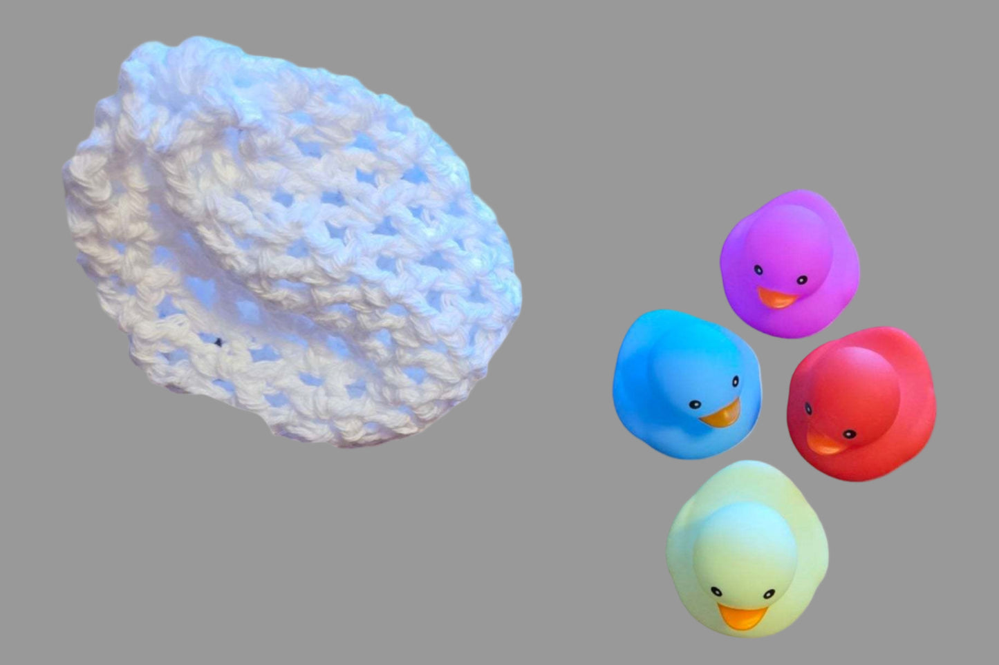 Newborn white chunky yarn hat with ears and four colorful baby rubber ducks for bath time in a baby gift basket set