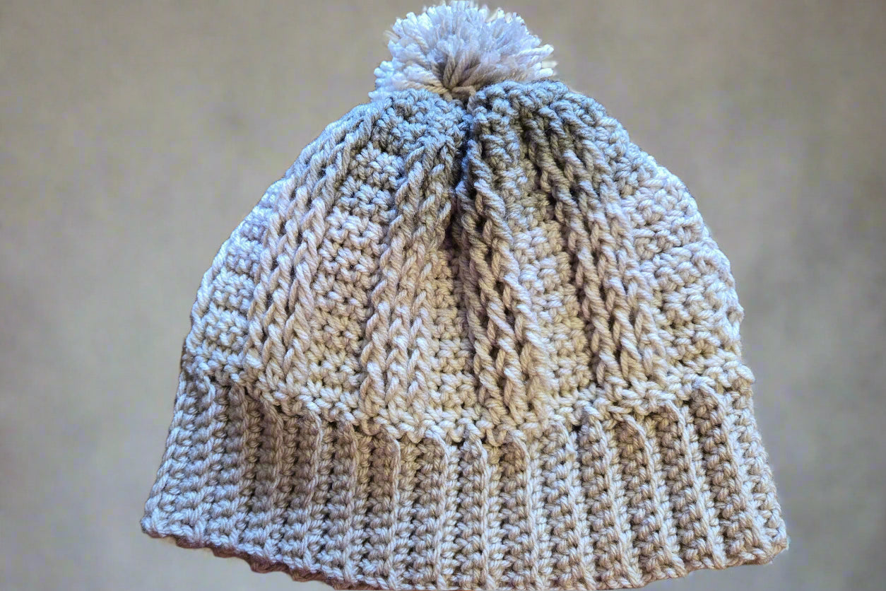 Handmade crocheted winter hat in light and dark gray with a pom-pom.