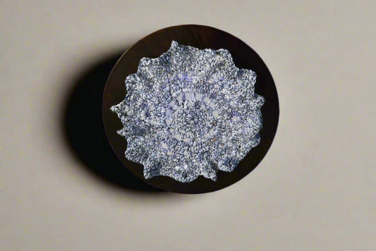 handmade vintage doily in blue with white specs on dark wooden surface