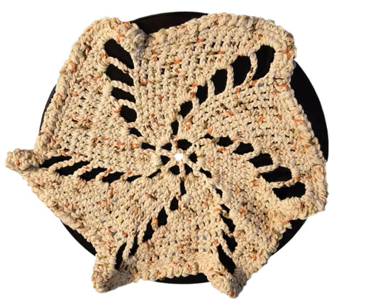 Vintage doily with spiral design handmade from cream cotton string placed on black surface