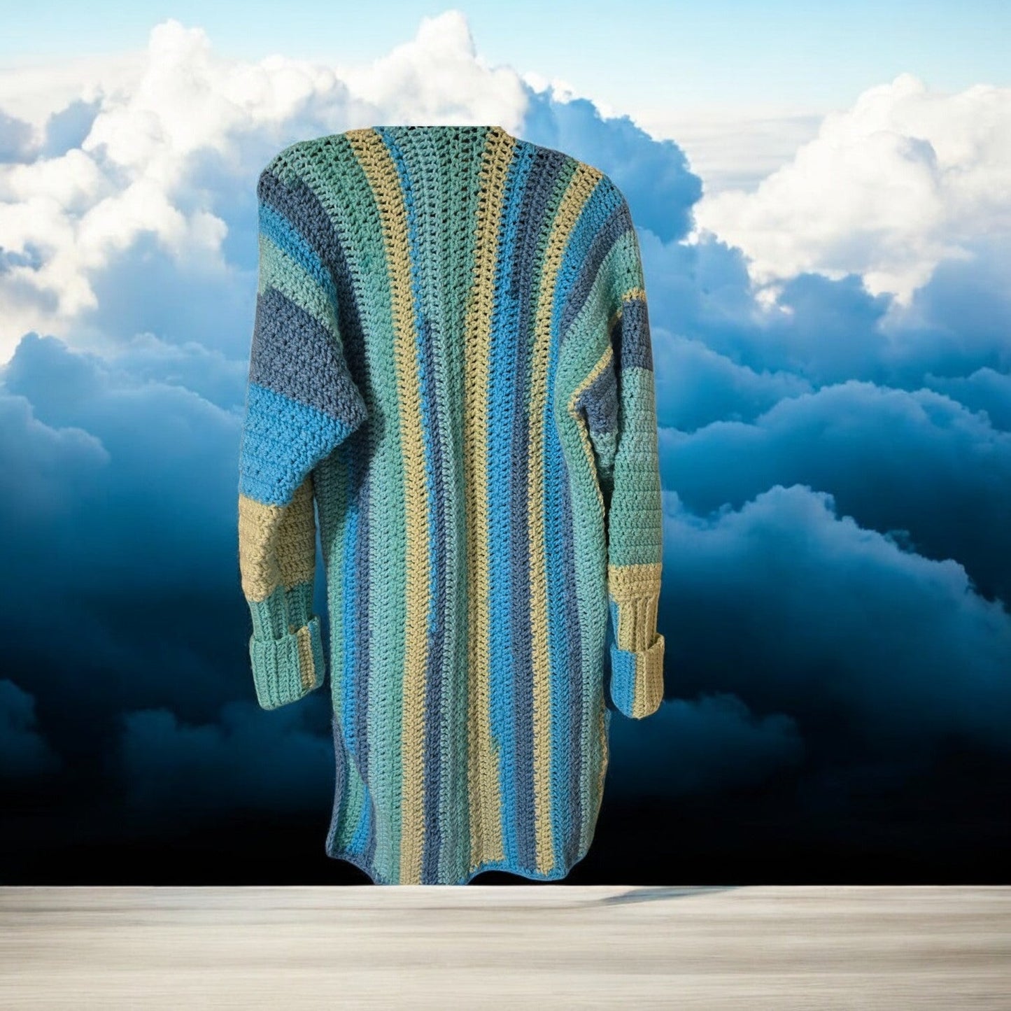 Bright multicolored sweater cardigan with long sleeves against a cloud backdrop.