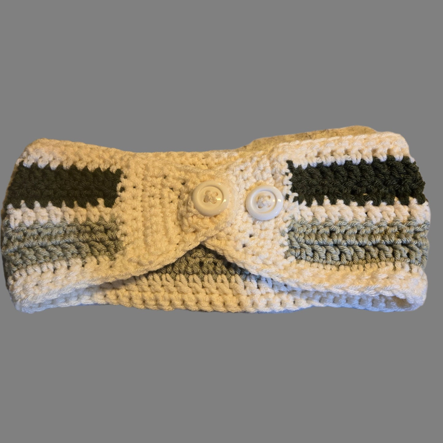 Knitted winter head band in greens and cream with buttons.