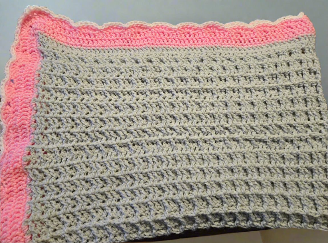 Handmade oversized baby blanket in pink and gray with tight knit pattern for warmth and comfort