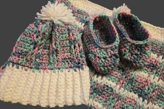 Handmade multicolored baby blanket set with matching hat and slippers featuring pom poms