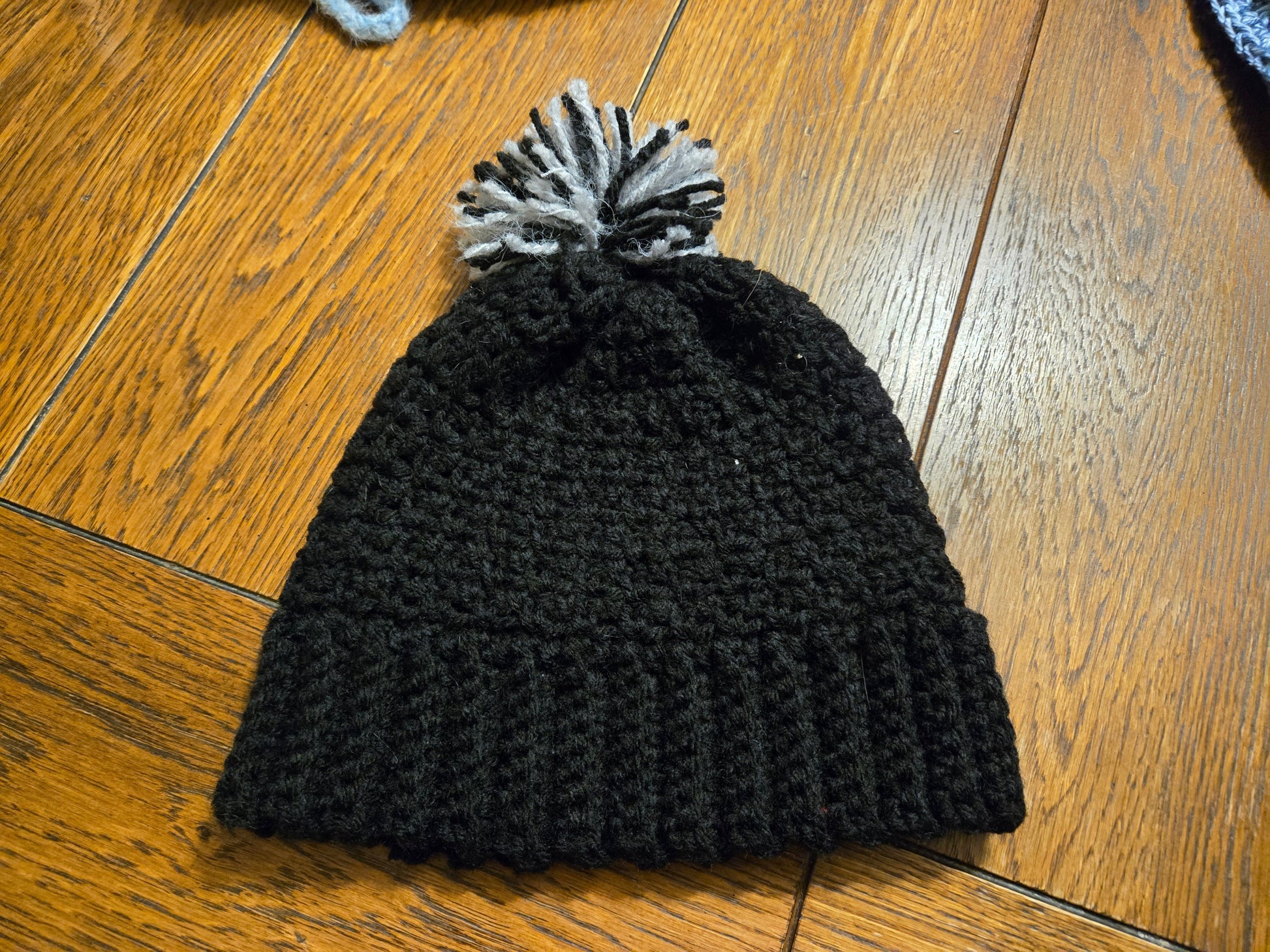 Black youth hat with pom pom, 19-inch circumference, 8 inches in height.