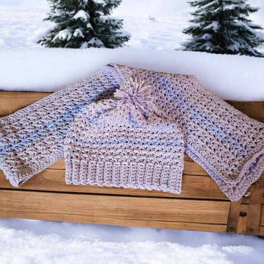 Voilet color hat and scarf set with pom pom, displayed on snowy bench.