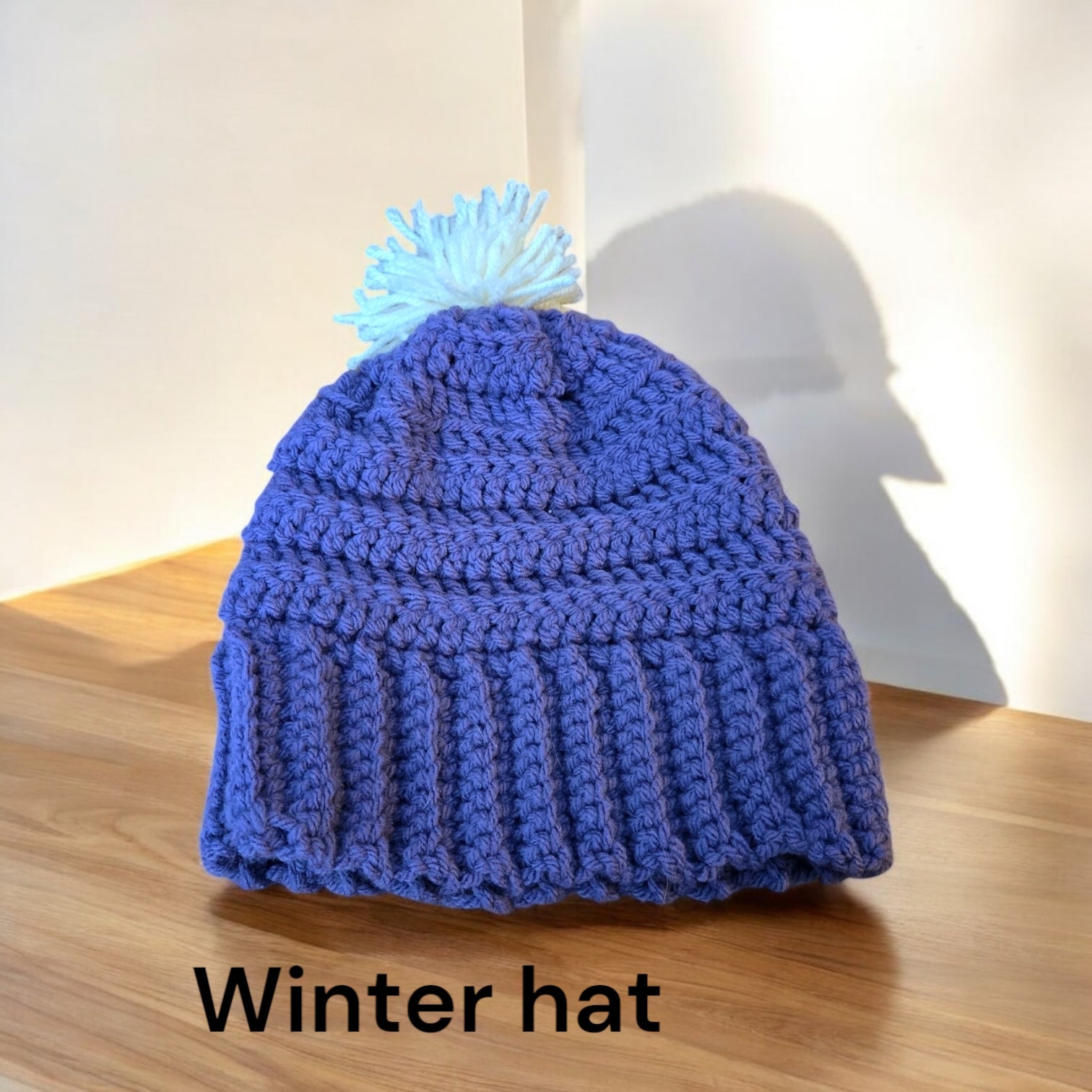 Purple handmade winter hat with pom-pom, warm and thick for cold weather.