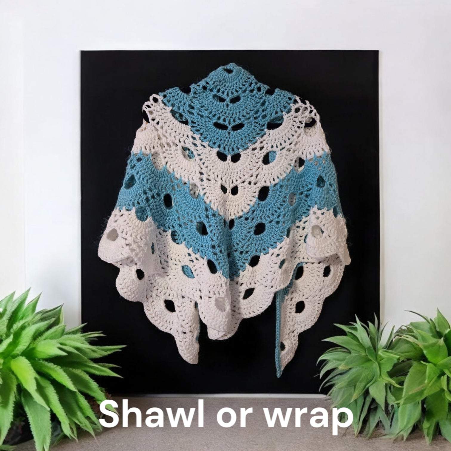 Designer handmade crocheted cotton shawl in blue and white displayed on black background