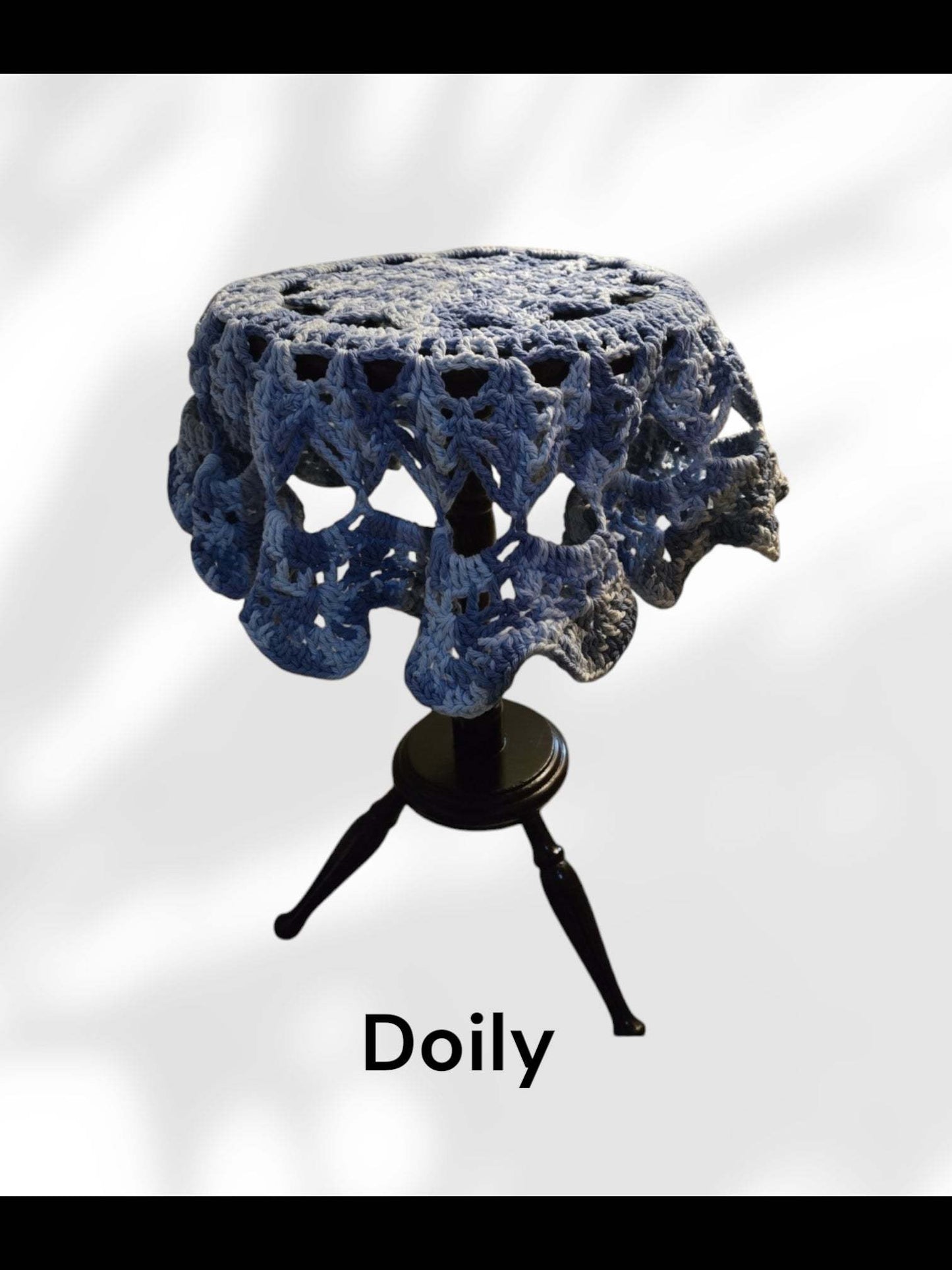 Vintage large blue and white handmade cotton doily on small wooden table