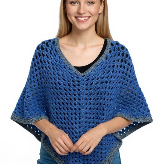 Handmade bright blue poncho with gray border worn by woman, crochet style, large size, cozy and stylish outerwear