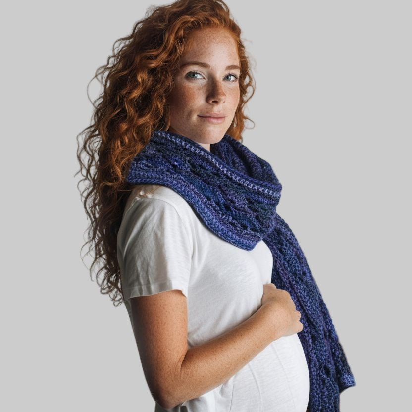 Woman wearing a decorative scarf in deep blue with white t-shirt on gray background